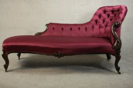 A Victorian show wood spoon back chaise longue with a button back upholstered in purple satin and
