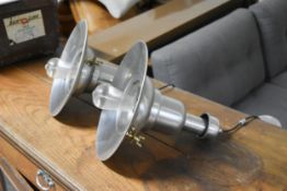 A pair of industrial style metal pendant ceiling lamps.