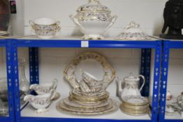 A Spode gilded and blue scrolling foliate design dinner service, including tureens, serving