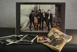 A collection of The Clash memorabilia, including various A4 black and white photos and a framed
