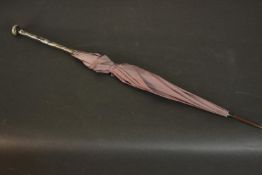 An early 20th century Paragon purple silk parasol, the end of the purple pearlescent plastic