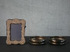 A pair of silver and oak wine coasters (hallmarked: London, 1966) along with a silver repousse