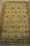 A fine hand made Kashmir Indian carpet with scrolling foliate motifs on a biscuit ground within