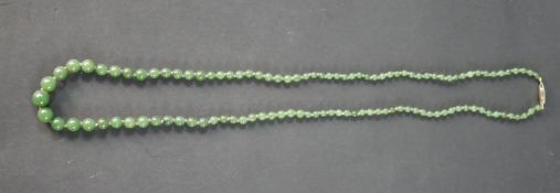 An antique gradated knotted jade bead necklace with hook and push clasp. The necklace contains 111