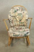 An Ercol elm and beech hoop back rocking chair, with loose back and seat cushions, bearing maker's