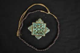 A Tibetan silver and turquoise Gau box pendant along with a string of graduated garnet beads on gold