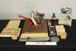 An Adana 2 Highspeed printing press with trays of metal letters and other accessories. H.15 W.30 D.