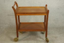 A circa 1960s teak two tier trolley of simple form on castors. H.74 W.70 D.42cm.
