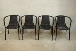 A set of four contemporary powder coated metal framed garden chairs, with woven wicker upholstery.