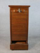 A late Victorian walnut tambour fronted filing cabinet, fitted with shelves, on a plinth base. H.116
