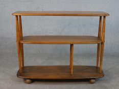 An Ercol blonde elm three tier trolley bookcase, model 361, raised on wheels. H.70 W.89 D.31cm