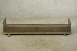 A late 19th century pierced brass fender raised on lion law feet. H.19 W.127 D.34cm.