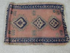 A 20th century Afghan Kazak style blue, pink and green rug with three central lozenges. L.46 W.60cm.
