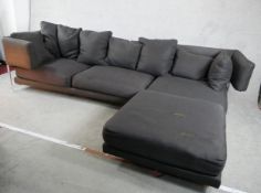 A contemporary grey upholstered L shaped modular settee raised on chrome plated supports. H.73 W.297