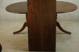A 20th century Regency style mahogany twin pedestal dining table, raised on turned columns on tripod