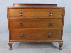 An early 20th century mahogany veneered chest of three long drawers, with swing handles, raised on