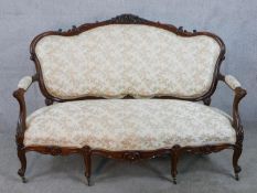A 20th century French carved mahogany framed open arm settee, upholstered in cream fabric, raised on