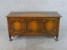 An early 20th century oak three panel blanket box raised on turned supports terminating on pad feet.