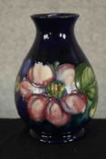 An early 20th century Moorcroft pottery baluster vase, tube lined in the Clematis pattern, impressed