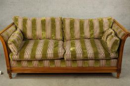 An early 20th century bergère and beech scroll arm two seater settee raised on fluted tapering