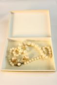A knotted graduated white coral bead necklace with white metal push clasp along with a pair of 18