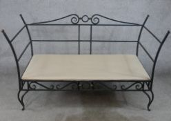 A contemporary painted iron garden two seater settee raised on pierced scrollwork style cabriole