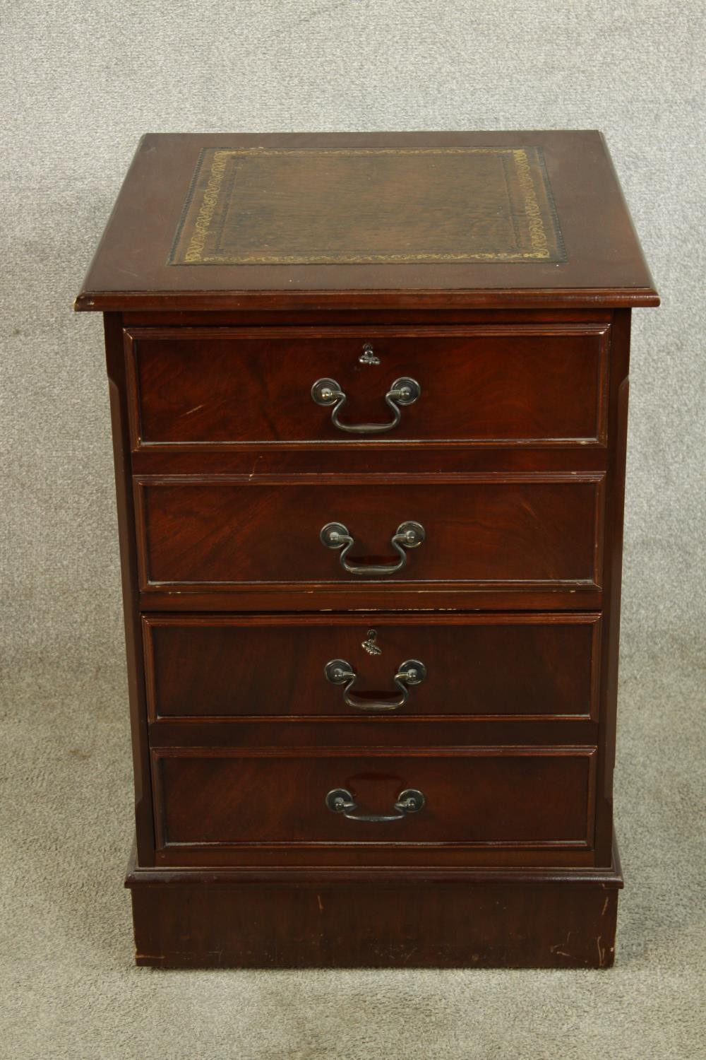 A contemporary Georgian style mahogany effect two drawer filing cabinet raised on plinth base and