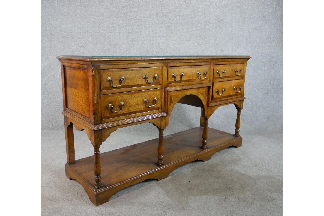 A 20th century oak five drawer sideboard with brass swing handles, raised on turned support with - Image 7 of 8