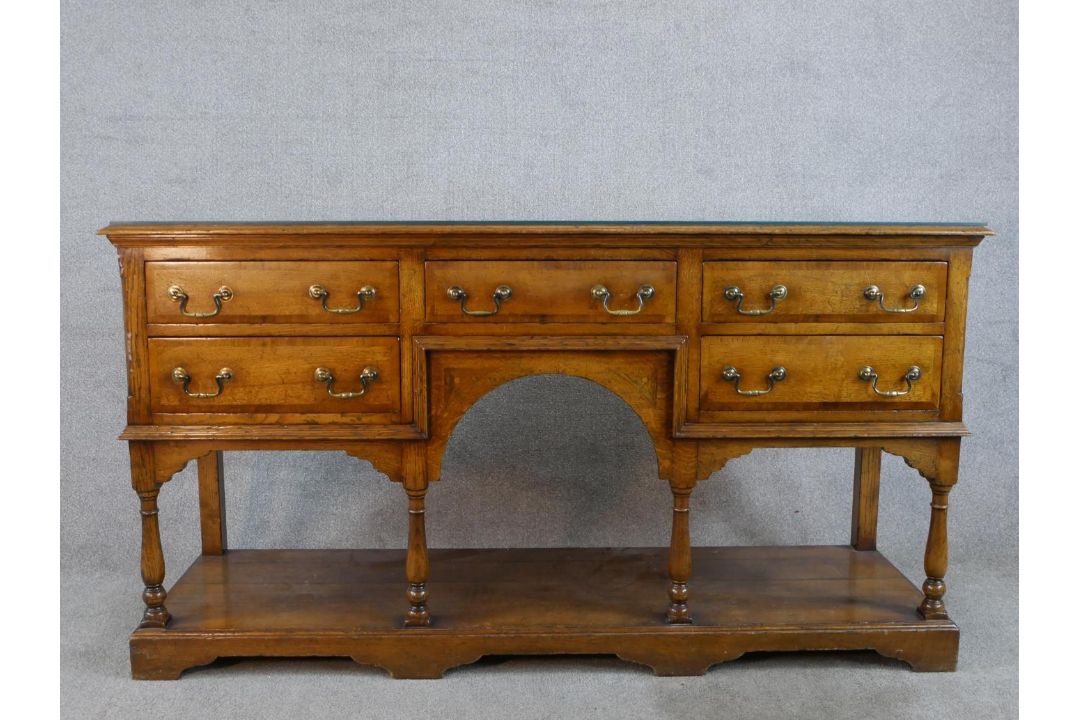 A 20th century oak five drawer sideboard with brass swing handles, raised on turned support with - Image 1 of 8