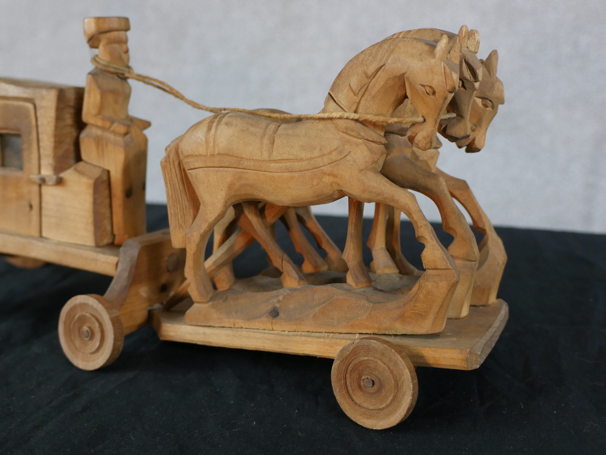 A 20th century carved hardwood toy in the form of a horse being pulling a coach, raised on wheels. - Image 2 of 4