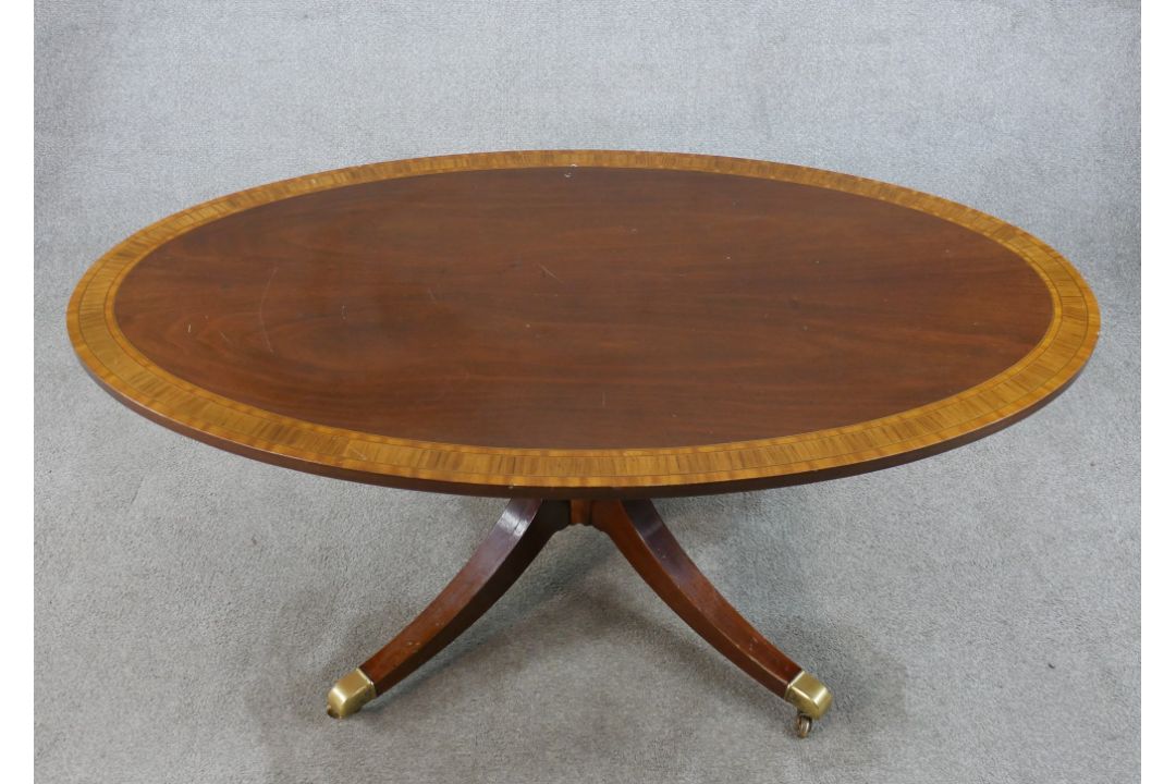 A Regency style inlaid mahogany oval coffee table raised on turned central column on four outswept - Image 1 of 6