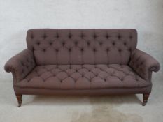A late 19th century mahogany framed button upholstered scroll arm settee, raised on square