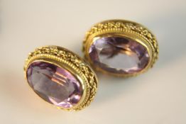 A pair of 18ct amethyst earrings. Each set with an oval mixed cut amethyst in a filigree rope