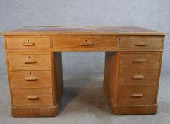 An early 20th century oak twin pedestal writing desk with red leather top. H.73 W.137 D.75cm