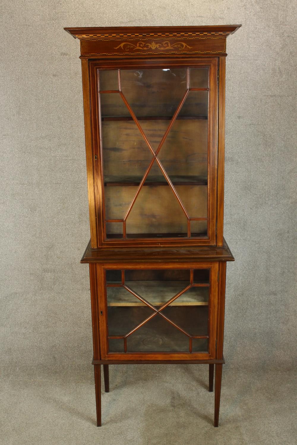 An Edwardian inlaid mahogany single door display cabinet, standing on single smaller single door