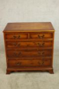 A contemporary chest of two short over three long graduating drawers with brass swing handles raised