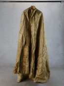 A 20th century gold silk theatrical cloak. H.180 W.80cm