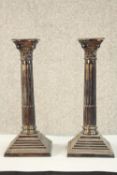 A pair of George V hallmarked silver Corinthian candlesticks, Birmingham 1972, raised on stepped