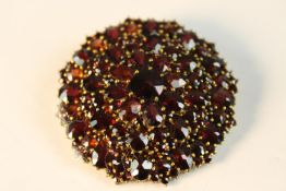 A large 19th century Bohemian gilt metal garnet set floral design brooch with secure hinged pin to