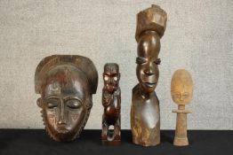 A 20th century carved West African wooden doll, a carved African tribal mask and two carved tribal