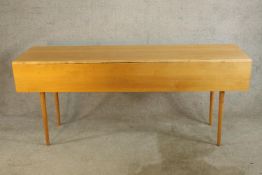 A contemporary beech wake style table raised on turned tapering supports. H.76 W.183 D.99cm. (
