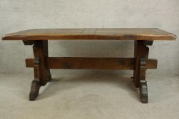 A contemporary stained pine refectory style raised on trestle supports united with central