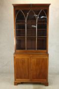 A 19th century mahogany bookcase with single glass panelled door above two cupboard door base