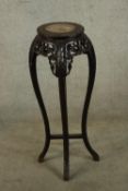 A 19th/early 20th century carved Chinese hardwood and marble plant stand raised on four curved