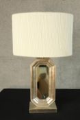 A contemporary silver painted octagonal shaped table lamp inset with mirror raised on rectangular
