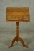 A 20th century stripped pine music stand with turned central column raised on three splayed supports