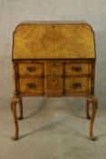 An early 20th century Queen Anne style walnut veneered fall front bureau opening to reveal fitted
