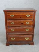 A contemporary Broyhill chest of four long drawers with brass swing handles raised on shaped bracket