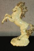 A 20th century Italian La Fiamma glazed pottery model of a rearing horse, marks to base. H.51cm.