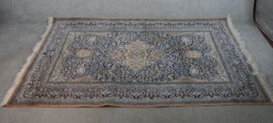 A 20th century green ground Persian carpet, the central diamond lozenge surrounded by floral